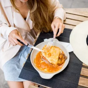 woman eating a Francesinha in portugal