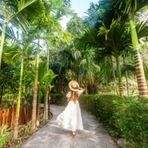 woman walking through greenery