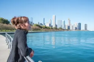 women standing in the City of Chicago downtown and she Walking around michigan lake at day time