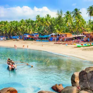 Beautiful Goa province beach in India with fishing boats and stones in the sea