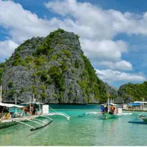 Outrigger boats ferry tourists in Coron, Palawan, Philippines.