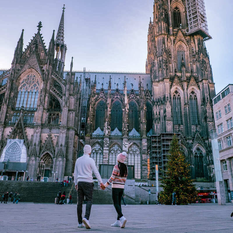 Young Couple Wearing Winter Clothes As They Admire Kolner Dom In Cologne, Western Germany, Northern Europe