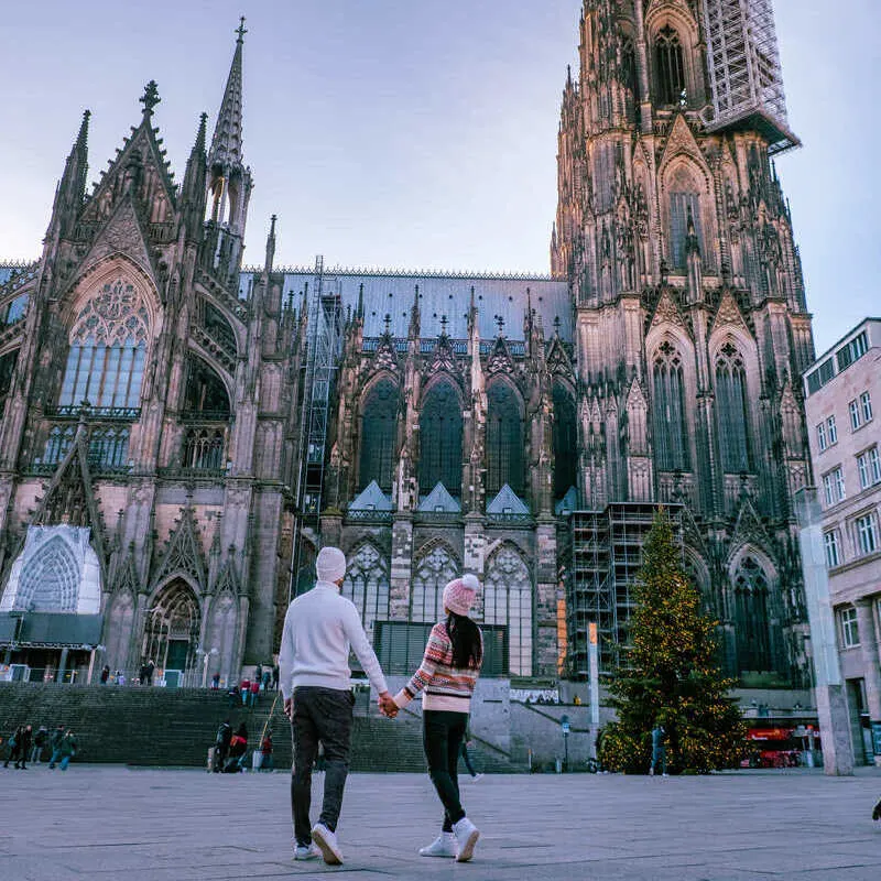 Young Couple Wearing Winter Clothes As They Admire Kolner Dom In Cologne, Western Germany, Northern Europe
