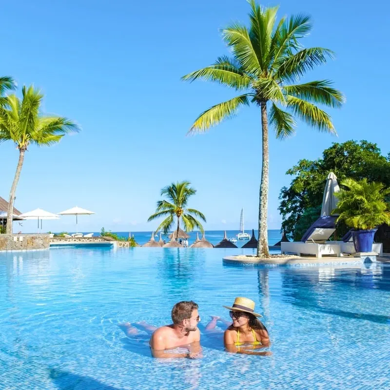 Couple Of Tourists Swimming In A Lagoon Style Pool In A Luxury Resort In Mauritius, East Africa