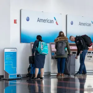 People using self-serve check-in kiosks for American Airlines inside Ronald Reagan Washington National Airport