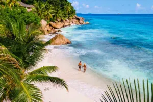 Aerial Shot Of Tourists Walking The Beach In Seychelles, East Africa