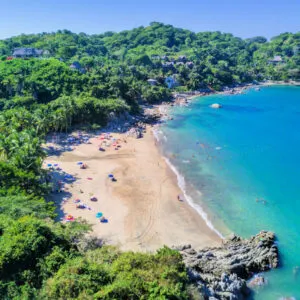 Panoramic aerial view of the beautiful beaches of Sayulita surrounded by greenery on a sunny day