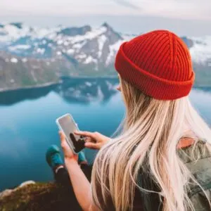 Woman blogger using smartphone navigation application traveling in Norway digital nomad