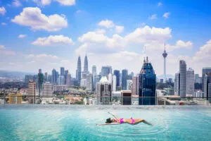 Female tourist swimming in pool overlooking Kuala Lumpur