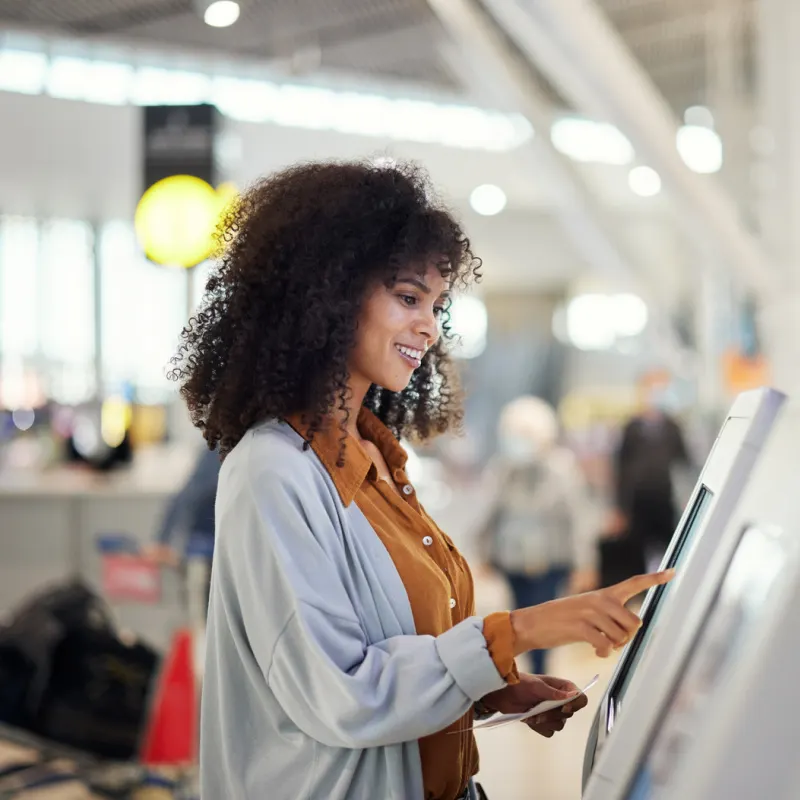 Female traveler using airport kiosk