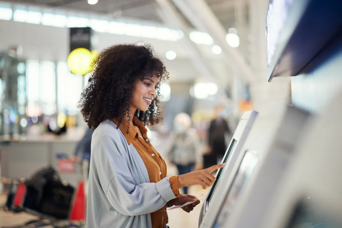 Female traveler using airport kiosk
