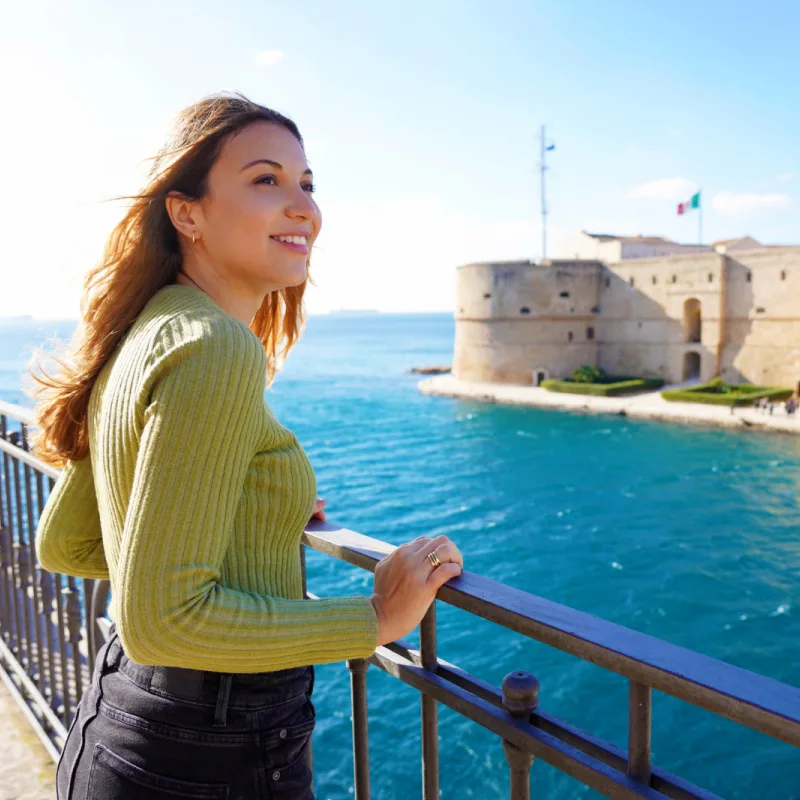 Woman overlooking Castello Aragonese, Taranto, Italy