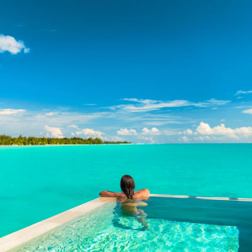 Woman swimming on an infinity pool in Turks and Caicos