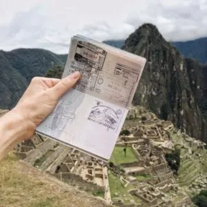 Young Traveler Holding Up A Passport With A Machu Picchu Novelty Stamp, Peru, South America.jpg