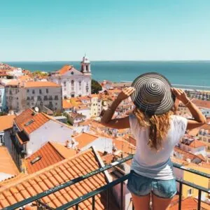 Young Woman Admiring A View Of Alfama In Lisbon, Portugal, Southern Europe