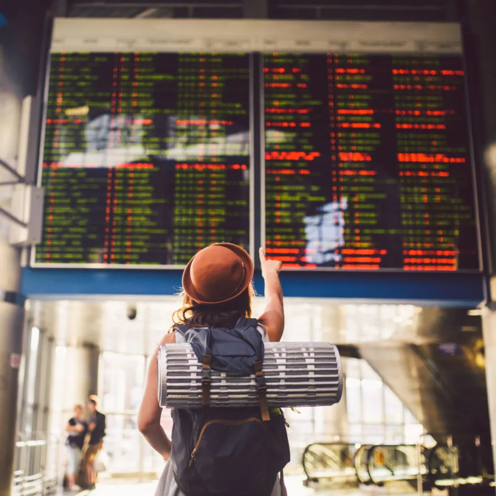 Female backpacker viewing airport departure board