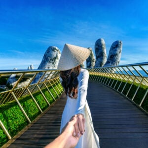 Tourist holding mans hand on Golden Bridge - Hoi An, Vietnam