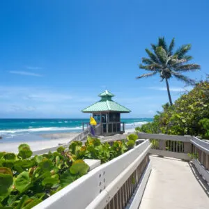 Boardwalk to beautiful Florida beach with crystal clear water and red rocks. Great place for snorkeling. Red Reef Park, Boca Raton, Florida USA