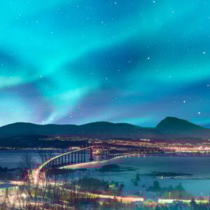 Aurora borealis or Northern lights in the sky over Tromso with Sandnessundet Bridge