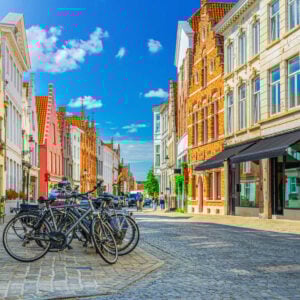 Brugge city historical center with bikes bicycles, stores and cafe windows on cobblestone street
