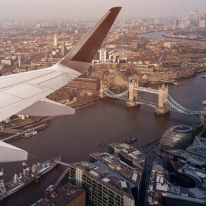 Plane Flying Over Central London On The Way To London City Airport With A View Of Tower Bridge, London, United Kingdom