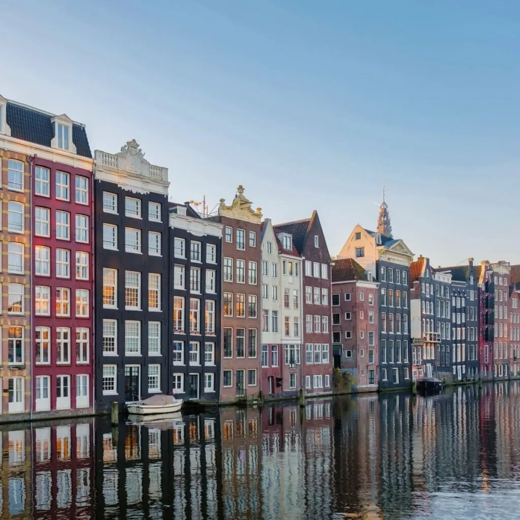 Colorful Houses Lining A Canal In Amsterdam, The Netherlands