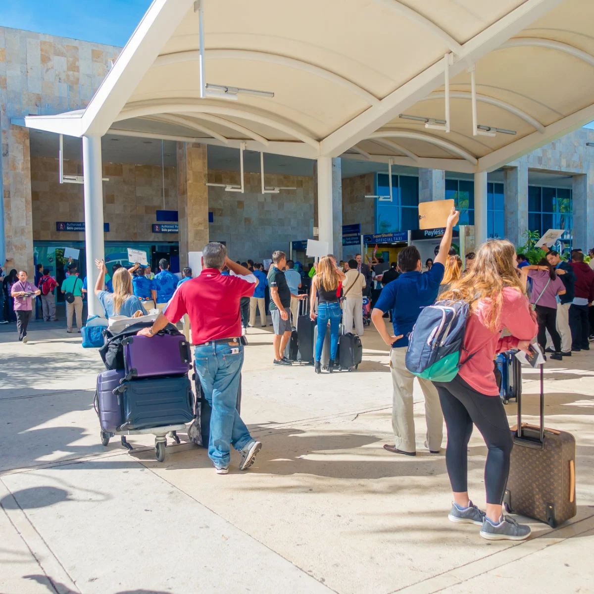 Travelers waiting for rides outside Cancun airport