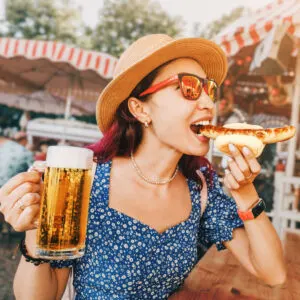 Woman with beer and sausage at festival