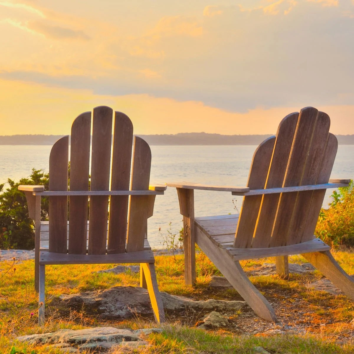 Adirondack chairs on cliff overlooking the water Narragansett Bay at sunset