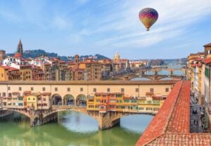 Hot air balloon flying over Ponte Vecchio over Arno river in Florence, Italy