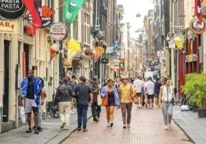 Many Travelers Walking and enjoying street of Amsterdam