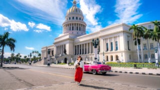 Woman posing near classic car in Havana on nice day