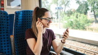 Woman on train listening to music
