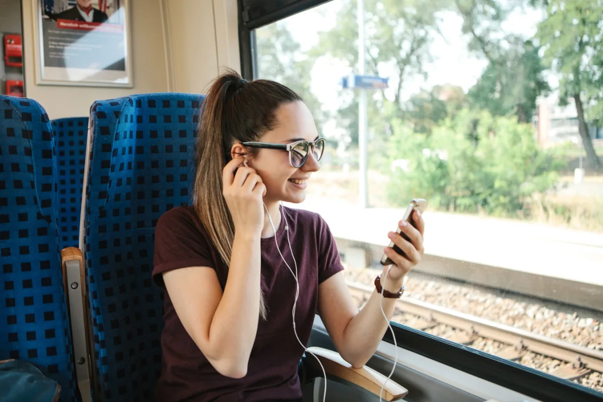 Woman on train listening to music