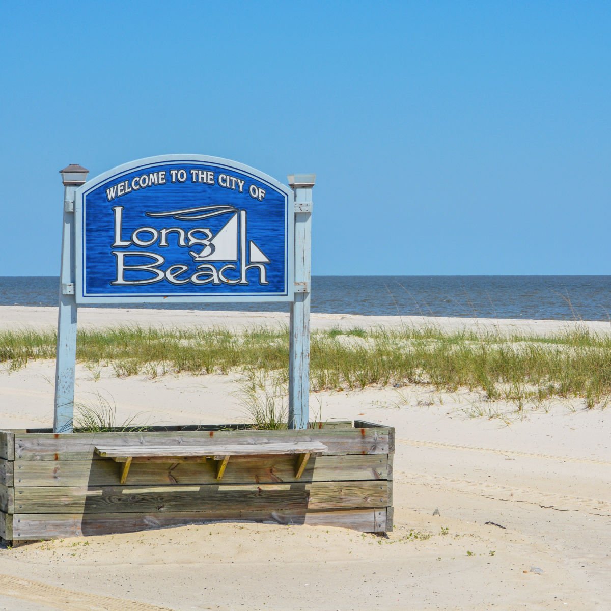 Long Beach (Mississippi) city sign on white sand beach
