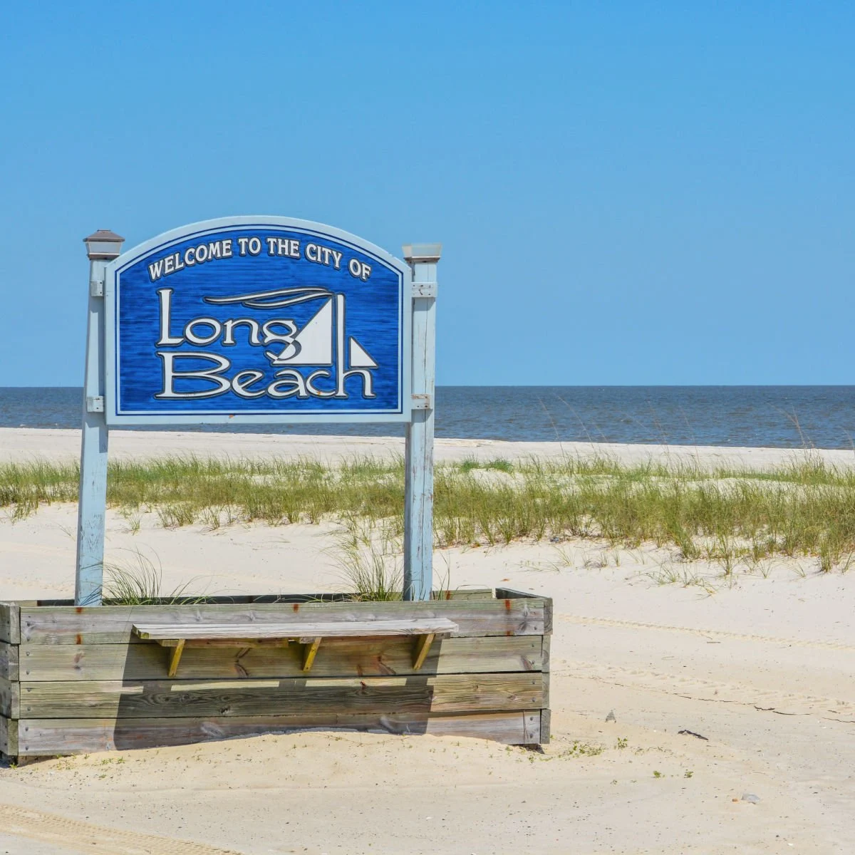 Long Beach (Mississippi) city sign on white sand beach
