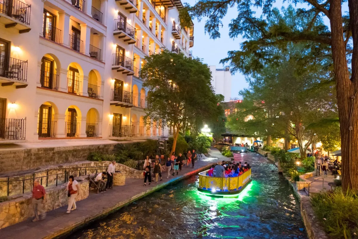 Move Over Austin! This Stunning Cultural City Crowned The Best In Texas Boat ride through San Antonio River Walk in evening