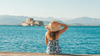 Female tourist posing in front of Nafplio's Bourtzi castle