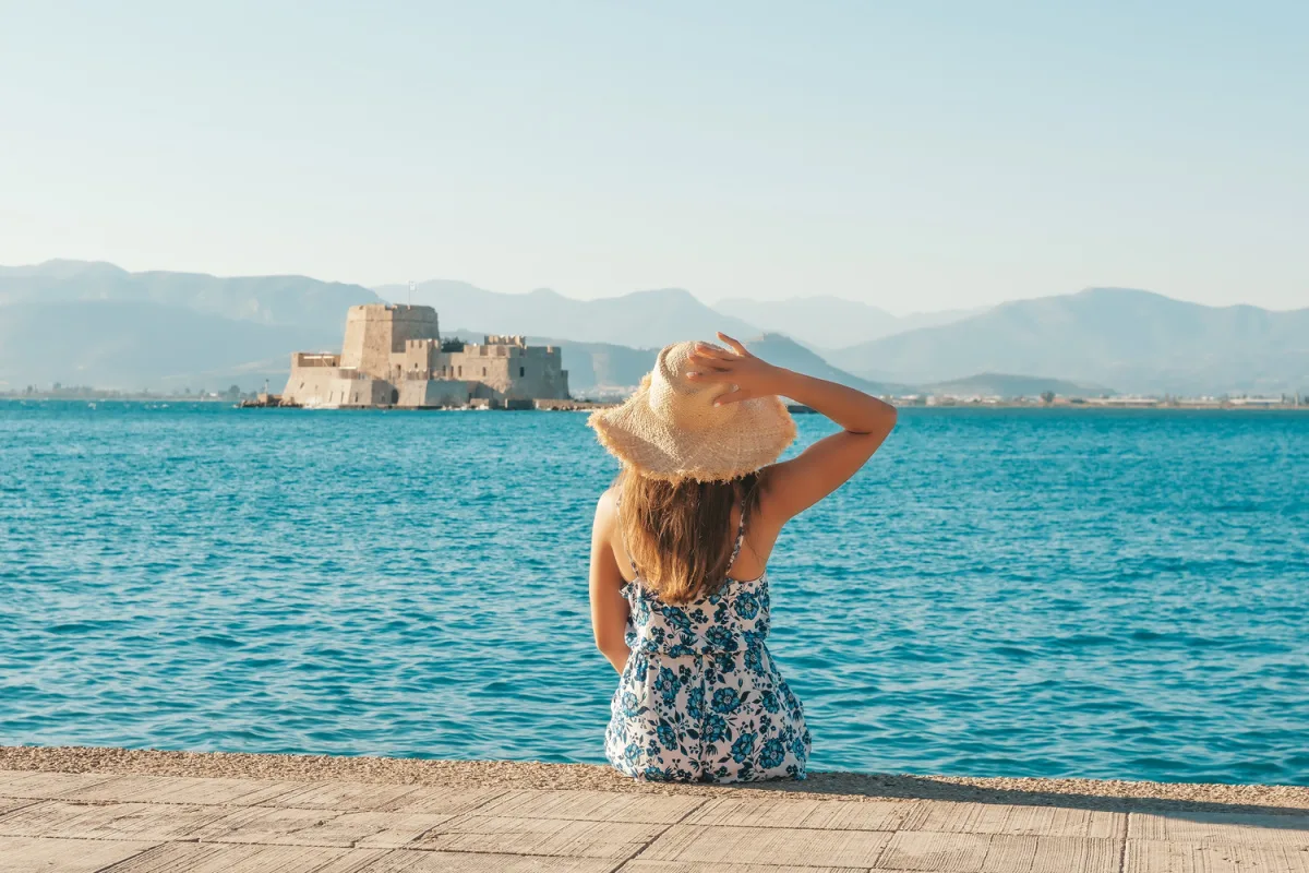 Female tourist posing in front of Nafplio's Bourtzi castle