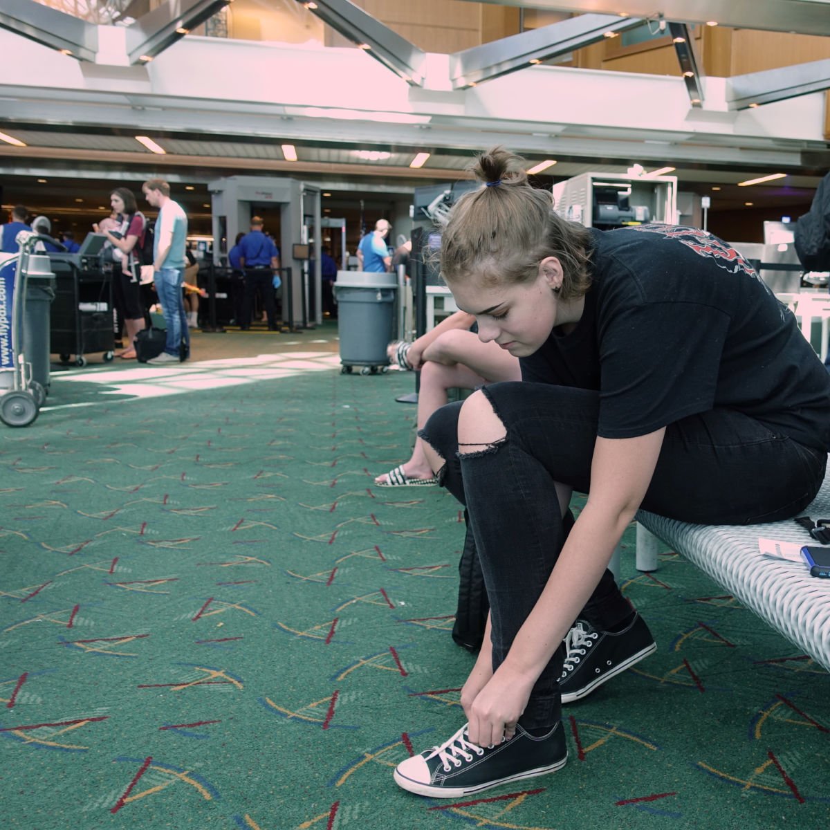 Traveler putting shoes on at TSA checkpoint