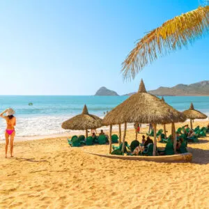 Vacationers relaxing under beach huts in Maztalan, Mexico