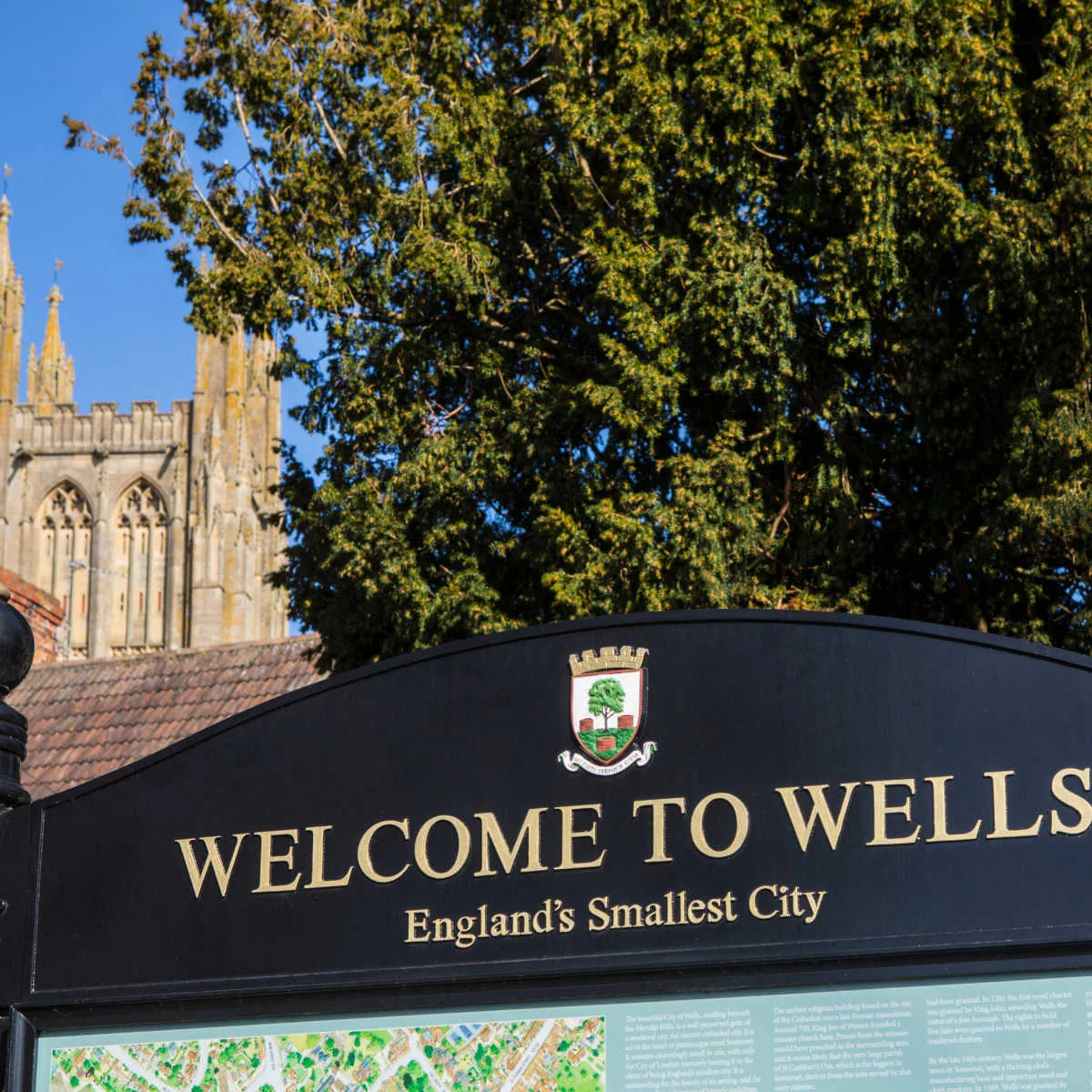 Wells, England welcome sign backdropped by cathedral