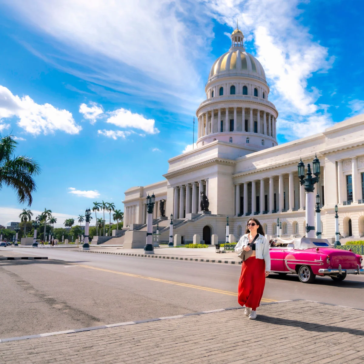 Woman posing near classic car in Havana on nice day