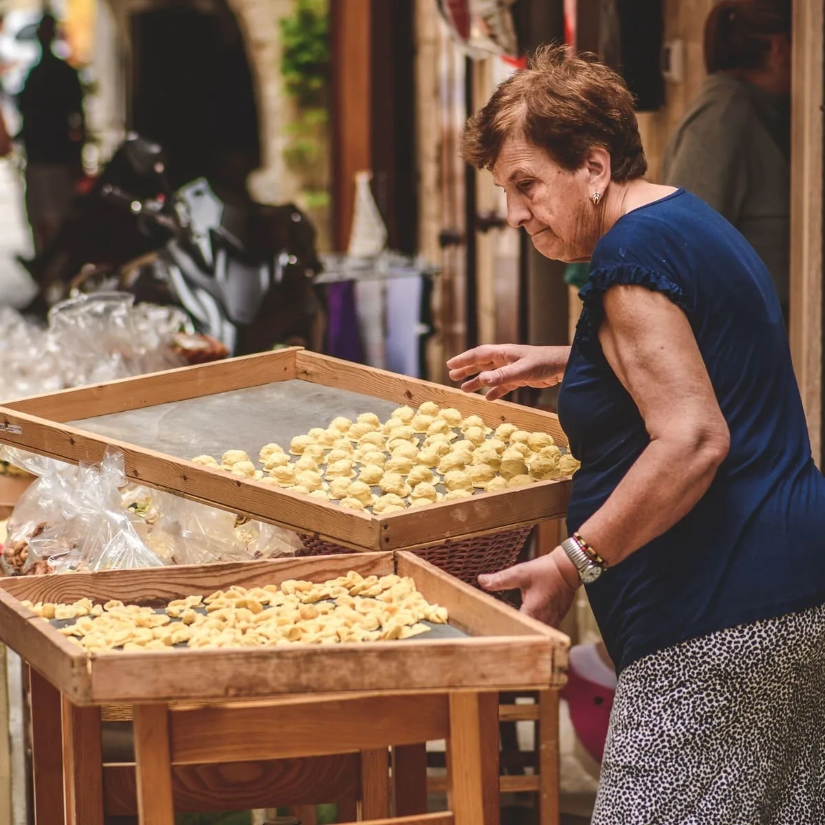 Americans Can Fly Nonstop To This Italian City With Cheaper Prices & Smaller Crowds Older Woman Selling Orecchiette In Bari, Italy
