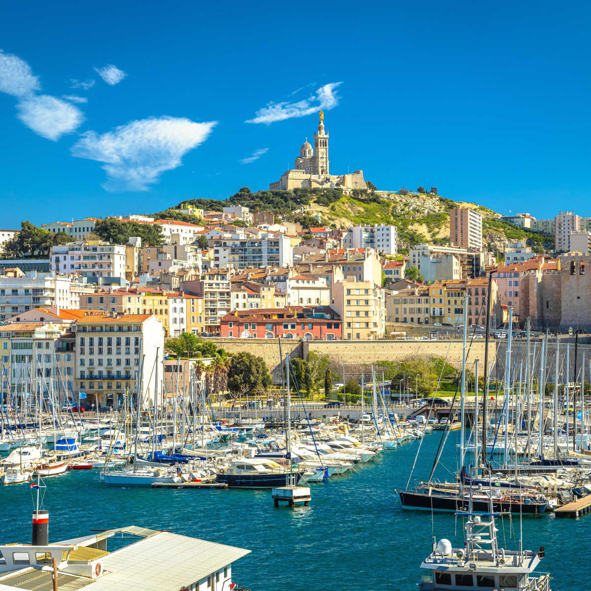 Harbor in Marseille with Basilique Notre-Dame de la Garde in the distance