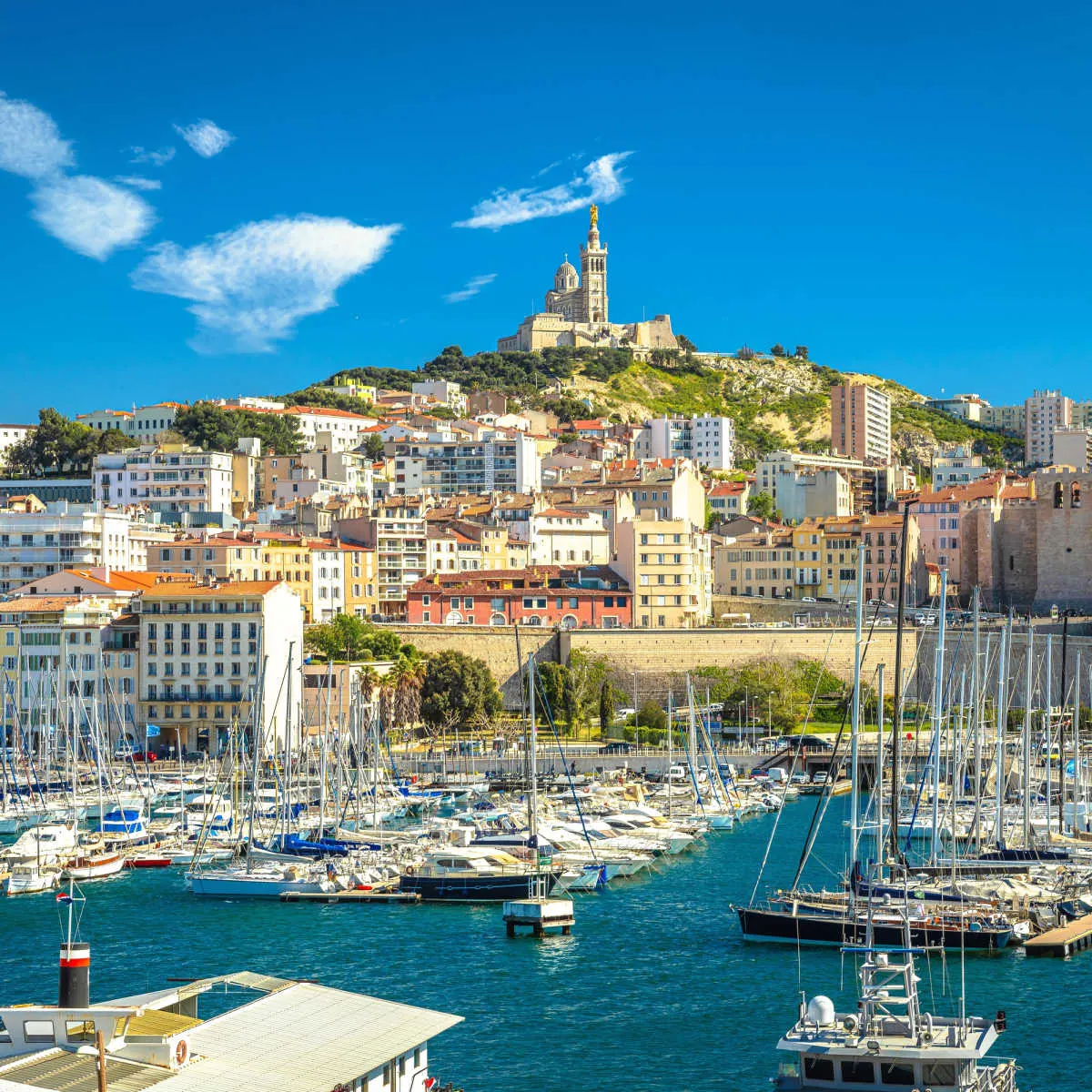 Harbor in Marseille with Basilique Notre-Dame de la Garde in the distance