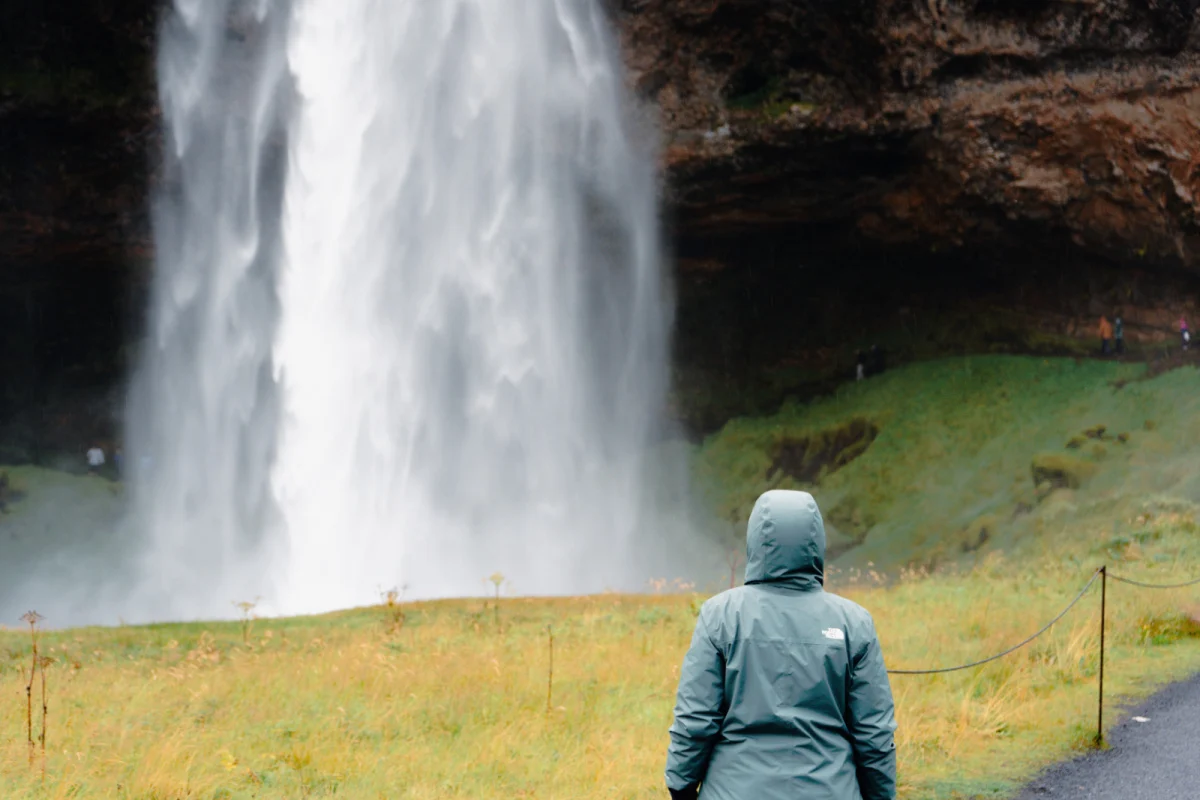Woman standing in front of in front of Seljalandsfoss Waterfall in Iceland