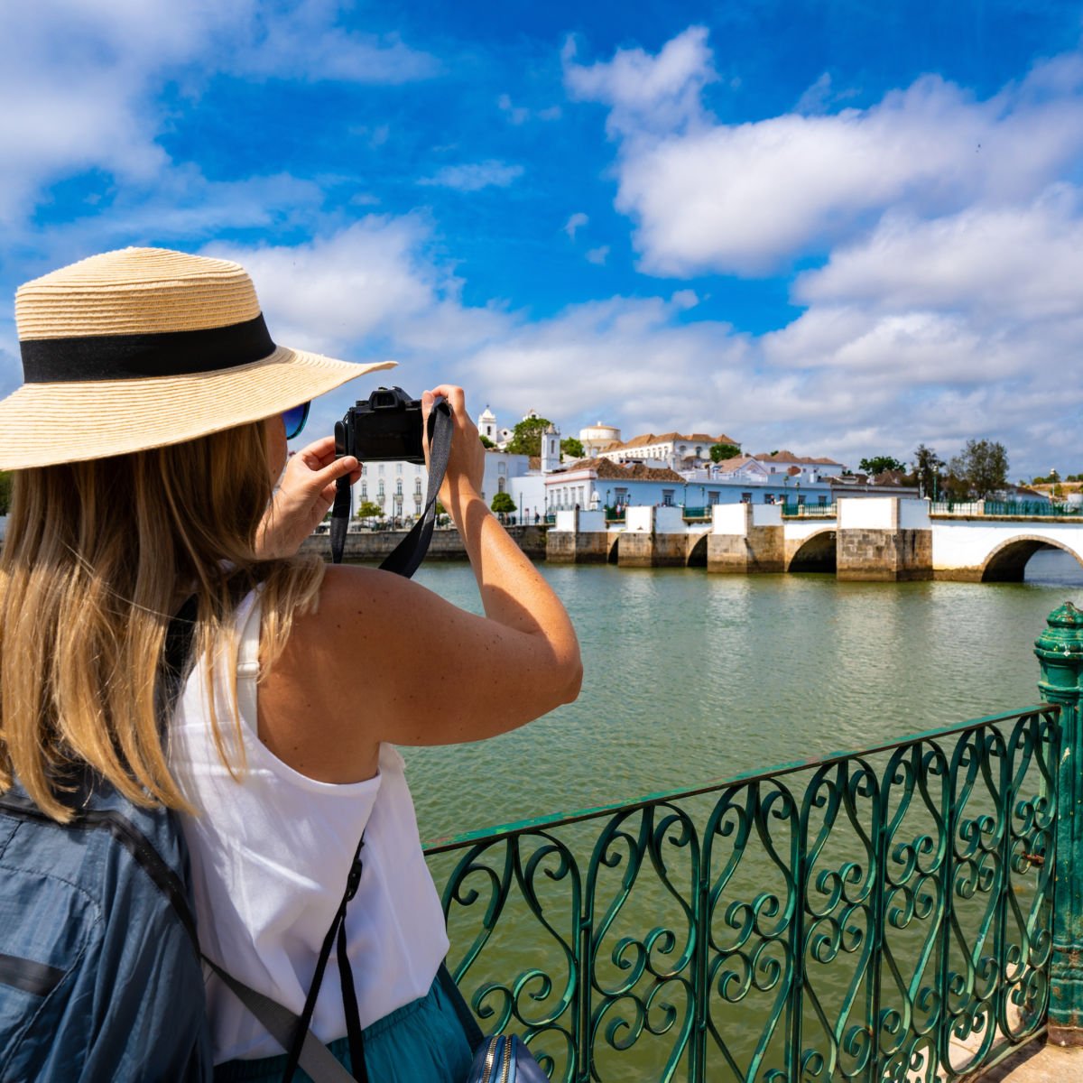 This Sunny Lesser Known Coastal City Is The 'Venice' Of Portugal Tourist taking photo of Tavira, Portugal canal