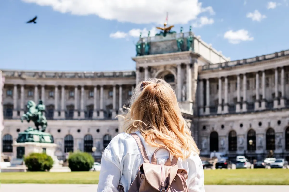 Woman looking to Hofburg complex in Vienna. Female tourist traveling in Austria