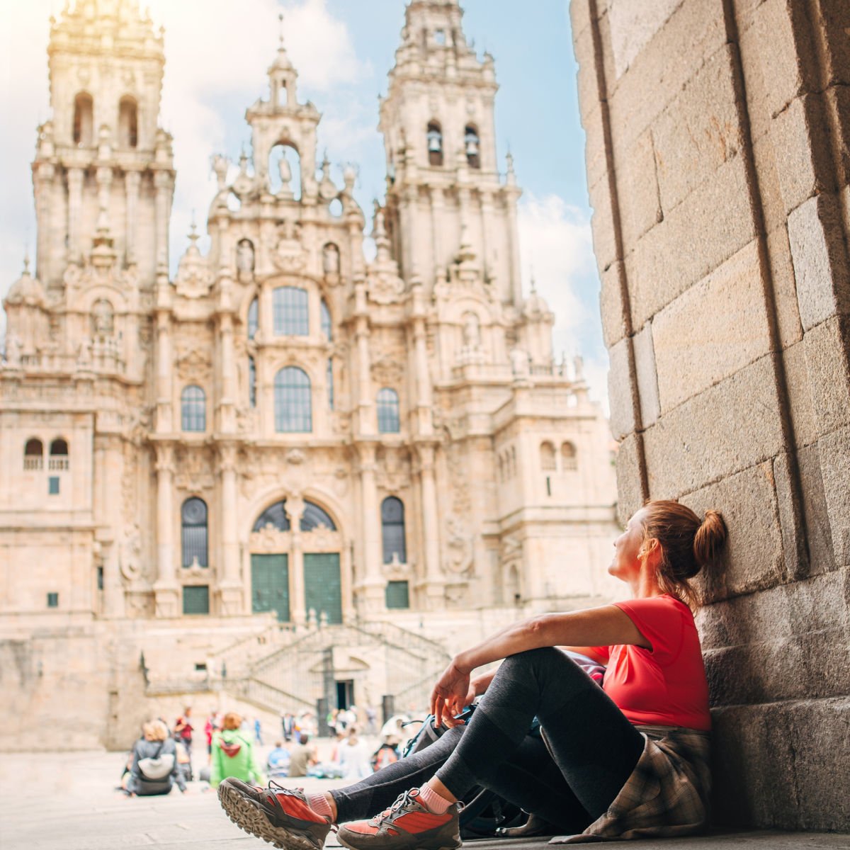 Woman sitting on Obradoiro Square in Santiago de Compostela, Spain